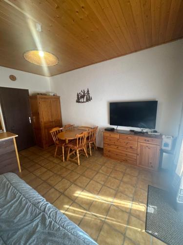 un salon avec une table et une télévision dans l'établissement La Marmotte, à Vars