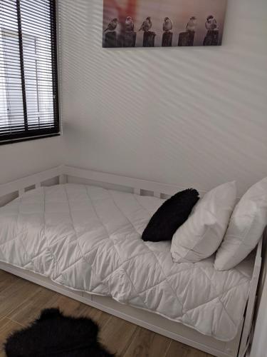 un lit avec des draps blancs et des oreillers dans une chambre dans l'établissement Centre Cannes 2-Bed Apt & garage 5min Croisette, à Cannes