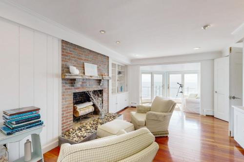 a living room with a brick fireplace and chairs at Magnolia Tides in Gloucester