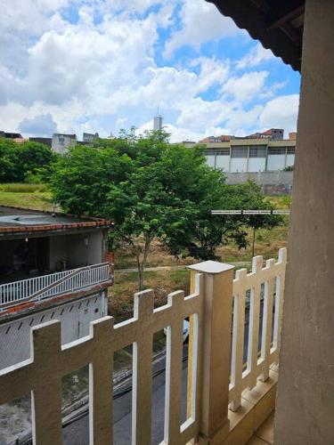 a view of a white fence from a balcony at Apartamento Completo em Osasco Tranquilo e Familiar in Osasco