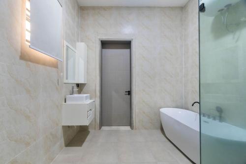 a bathroom with a tub and a sink and a toilet at Elegant 3 Bedroom Terrace Duplex in Lekki in Ikate