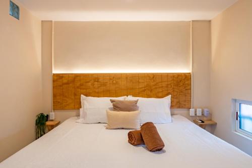 a bedroom with a white bed with two towels on it at Casa Jicama in Cancún