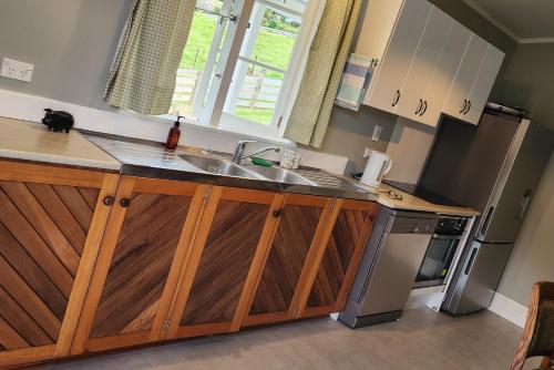 a kitchen with a sink and a refrigerator at Stuart's in Whangarei Heads