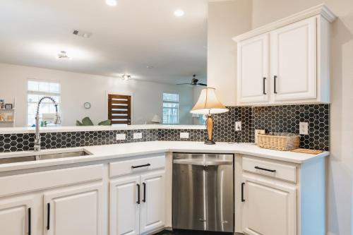 a kitchen with white cabinets and a sink at Holiday Escape- Pool, King Beds & Christmas New Year Ready in Austin