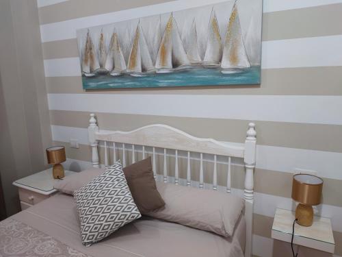 a bedroom with a bed and a painting of sailboats at Casa Aurora in Vecindario