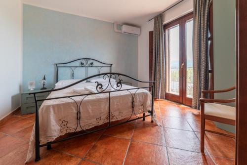 a bedroom with a bed and a large window at Agriturismo San Basilio in Salento