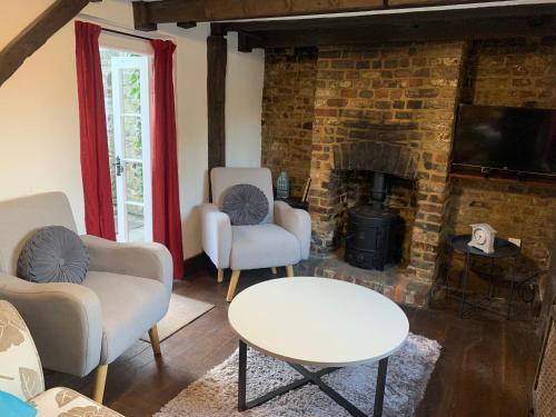 a living room with two chairs and a fireplace at Quay Cottage in Sandwich, UK in Sandwich