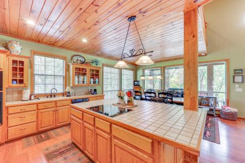 a kitchen with wooden cabinets and a large island at Riverfront Cabin on 2 Acres in Glenwood! in Glenwood