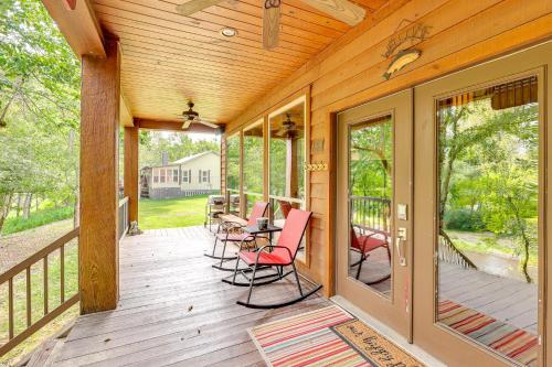 a wooden porch with chairs and a table on it at Riverfront Cabin on 2 Acres in Glenwood! in Glenwood