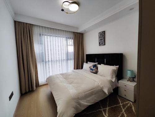 a bedroom with a large bed and a window at Soft Life Crib in Lavington - Dine, Wine & Relax in Nairobi