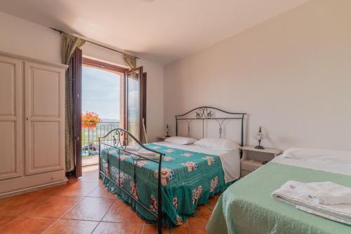 a bedroom with two beds and a balcony at Agriturismo San Basilio in Salento