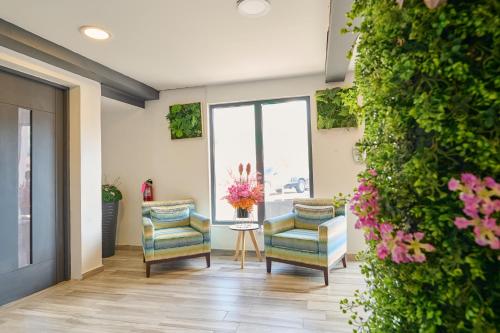 a lobby with two chairs and a table with flowers at Central Boutique Hotel in Oranjestad