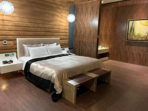 a bedroom with a large bed with a wooden wall at Aquarius Motel in Taichung