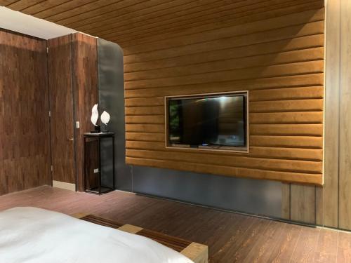 a bedroom with a flat screen tv on a wall at Aquarius Motel in Taichung