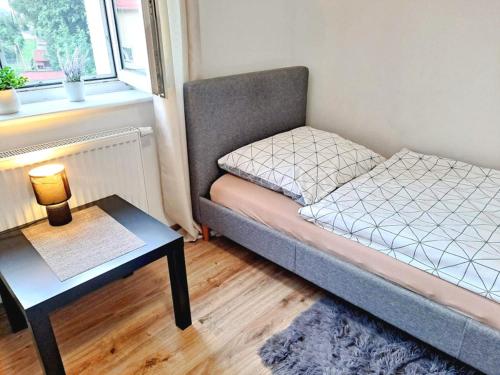 a small bed in a small room with a table at Pokoje po drodze w Barczewie in Barczewo