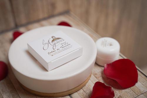 a white cake on a table with red flowers at HOTEL & SPA LOS AGAVES Tepotzotlán in Las Ánimas