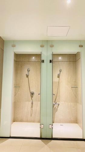 a glass shower stall with two shower heads at Aquarius Motel in Taichung