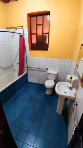 a bathroom with a white toilet and a sink at La Posada Colonial in Quito