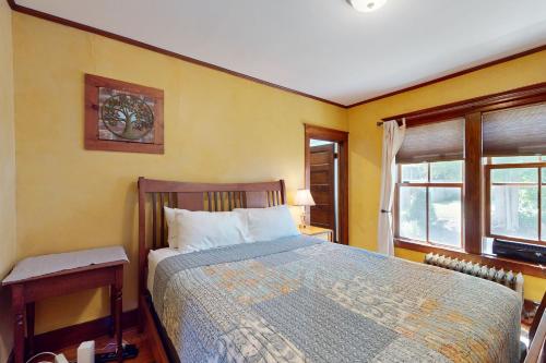 a bedroom with a bed and two windows at The Worden House in Manchester