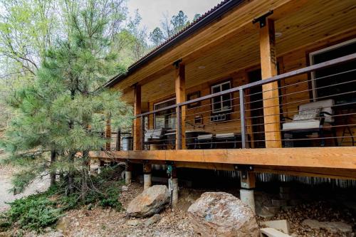 グレンデールにあるThe Hideaway Concealed Cabin East Zion & Bryceのデッキ付きのログキャビン