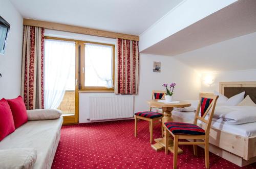 a hotel room with a bed and a table and chairs at Apart Petra - Silvretta Card Premium Betrieb in Galtür