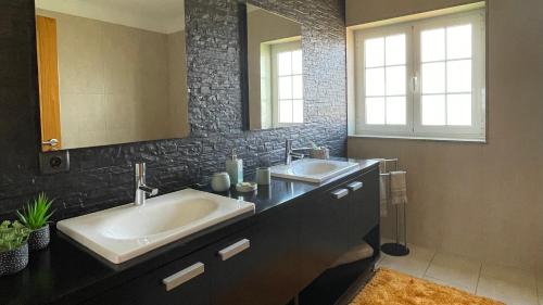 a bathroom with two sinks and a mirror at Cantinho do Minho - Ponte de Lima in Ponte de Lima