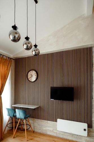 a living room with a table and a clock on a wall at CROWNE Stan11550 Sopstveno Parking Mesto in Lazarevac