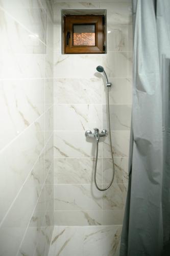 a bathroom with a shower with white marble tiles at CROWNE Stan11550 Sopstveno Parking Mesto in Lazarevac