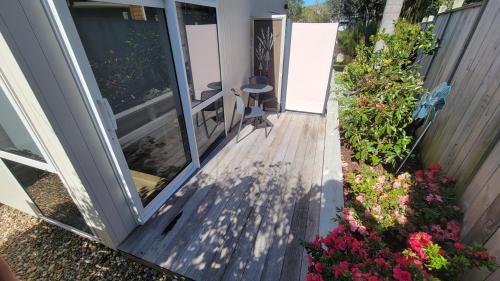 an open door to a porch with flowers on it at Margaritaville Hahei in Hahei