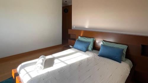 een slaapkamer met een groot bed met blauwe kussens bij Cantinho do Minho - Ponte de Lima in Ponte de Lima
