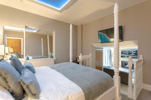 a bedroom with a bed and a large mirror at Aphrodites Group - Luxury Hot Tub Suites in Central Lake District! in Bowness-on-Windermere