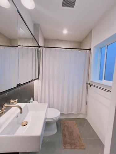 a bathroom with a white sink and a toilet at Charming 2BR Cottage with Bay and City Views-Gated Luxury Private Place in San Francisco