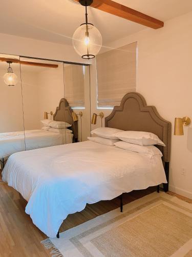 a bedroom with a large white bed with a large mirror at Charming 2BR Cottage with Bay and City Views-Gated Luxury Private Place in San Francisco