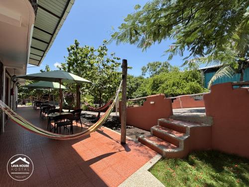 a porch with a rope swing and a table and chairs at Lava House Hostal in Puerto Ayora