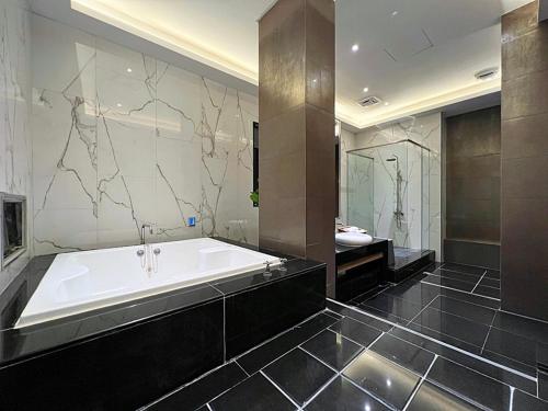 a large bathroom with a tub and a sink at Aquarius Motel in Taichung
