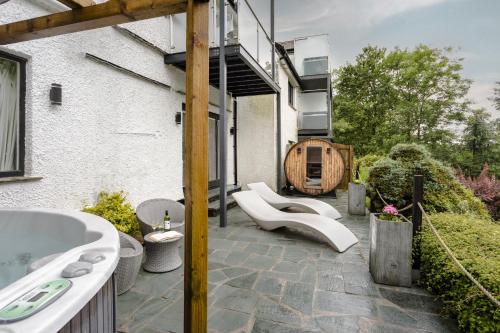 a bathroom with a tub and a sink on a patio at Aphrodites Group - Luxury Hot Tub Suites in Central Lake District! in Bowness-on-Windermere