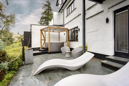 a bathroom with a tub and a sink on a patio at Aphrodites Group - Luxury Hot Tub Suites in Central Lake District! in Bowness-on-Windermere