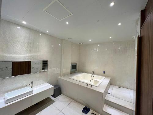 a white bathroom with a tub and a sink at Aquarius Motel in Taichung