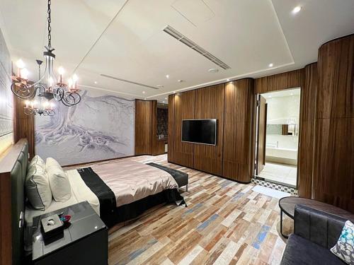 a bedroom with a bed and a tv and a couch at Aquarius Motel in Taichung