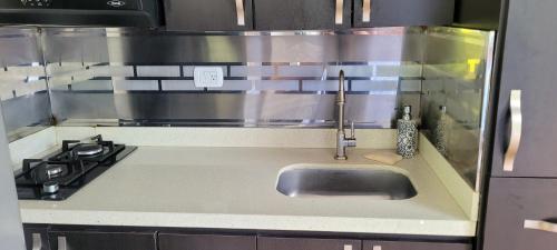 a kitchen with a sink and a stove at Cabaña en el Aire con jacuzzi a 5min del Pueblo in Sopetran
