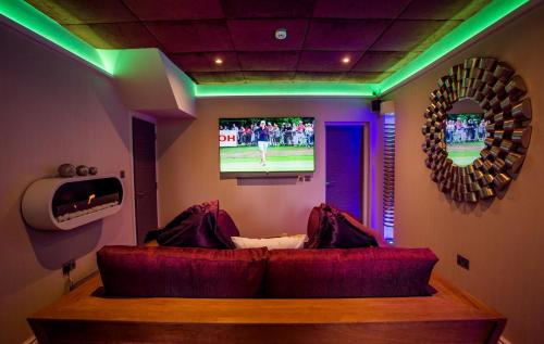 a living room with a couch and a tv at Aphrodites Group - Luxury Hot Tub Suites in Central Lake District! in Bowness-on-Windermere