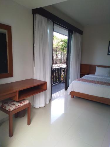 a bedroom with a bed and a desk and a window at Seminyak Apartment by LBV in Seminyak
