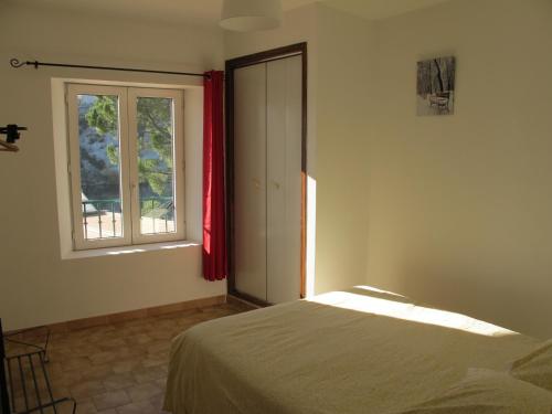 a bedroom with a bed and a window at Cairenou Location in Saint-Martin-dʼArdèche
