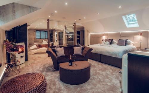a large bedroom with a bed and a couch and chair at Aphrodites Group - Luxury Hot Tub Suites in Central Lake District! in Bowness-on-Windermere