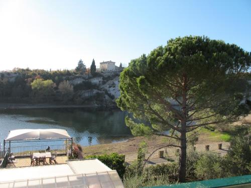 a view of a river with a tent and a tree at Cairenou Location in Saint-Martin-dʼArdèche