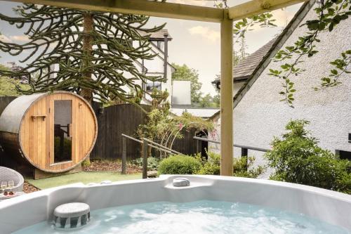 a bath tub in the backyard of a house at Aphrodites Group - Luxury Hot Tub Suites in Central Lake District! in Bowness-on-Windermere