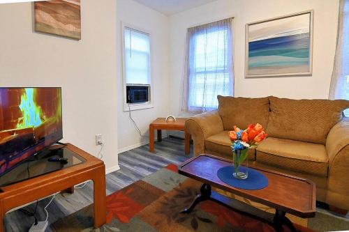 a living room with a couch and a tv at Hidden Gem-1Bedroom with Plenty Free Street Parking in Communipaw