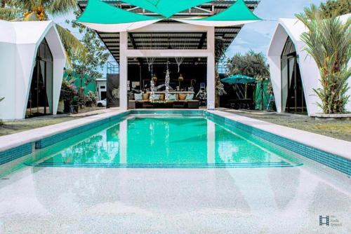 a swimming pool in front of a house at Alborada Boutique Stay in Uvita