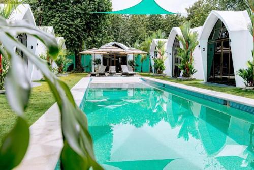 a swimming pool in front of a house at Alborada Boutique Stay in Uvita