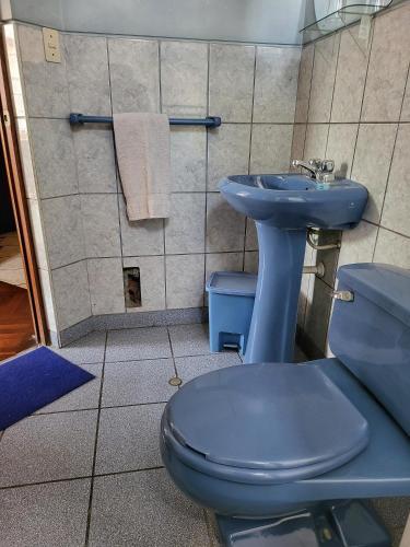 a bathroom with a blue toilet and a sink at D'Cardenas Hotel in Cajamarca